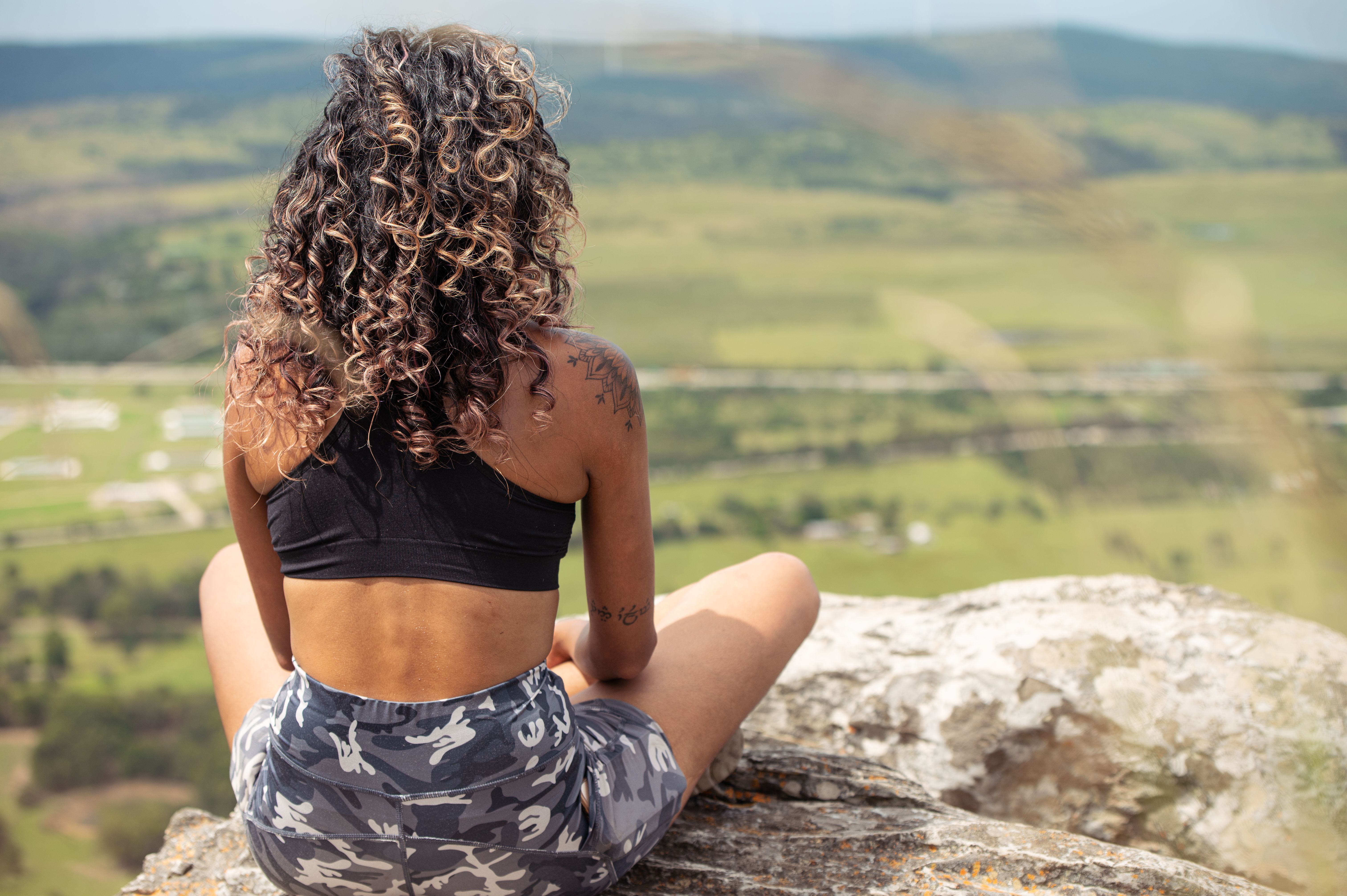 woman sitting on a rock in contemplation as she engages in an RV gratitude challenge as a digital nomad vanlifer